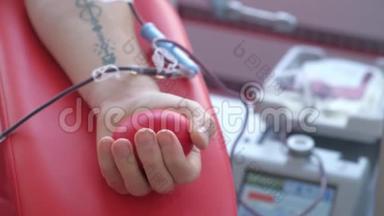 一个人在输血中心<strong>献血</strong>时挤压一个球。